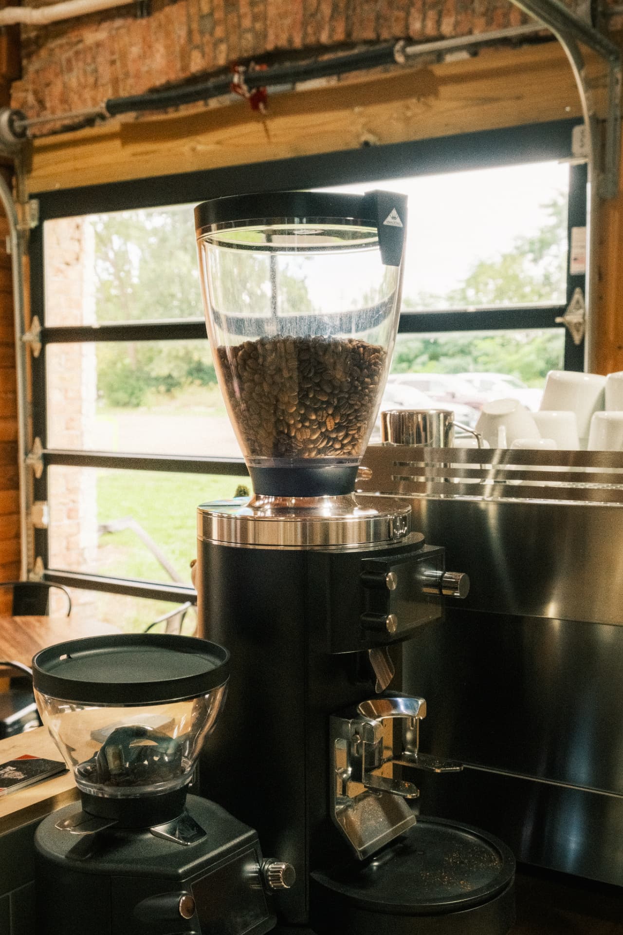 Coffee beans in the grinder hopper beside the DSCO espresso machine