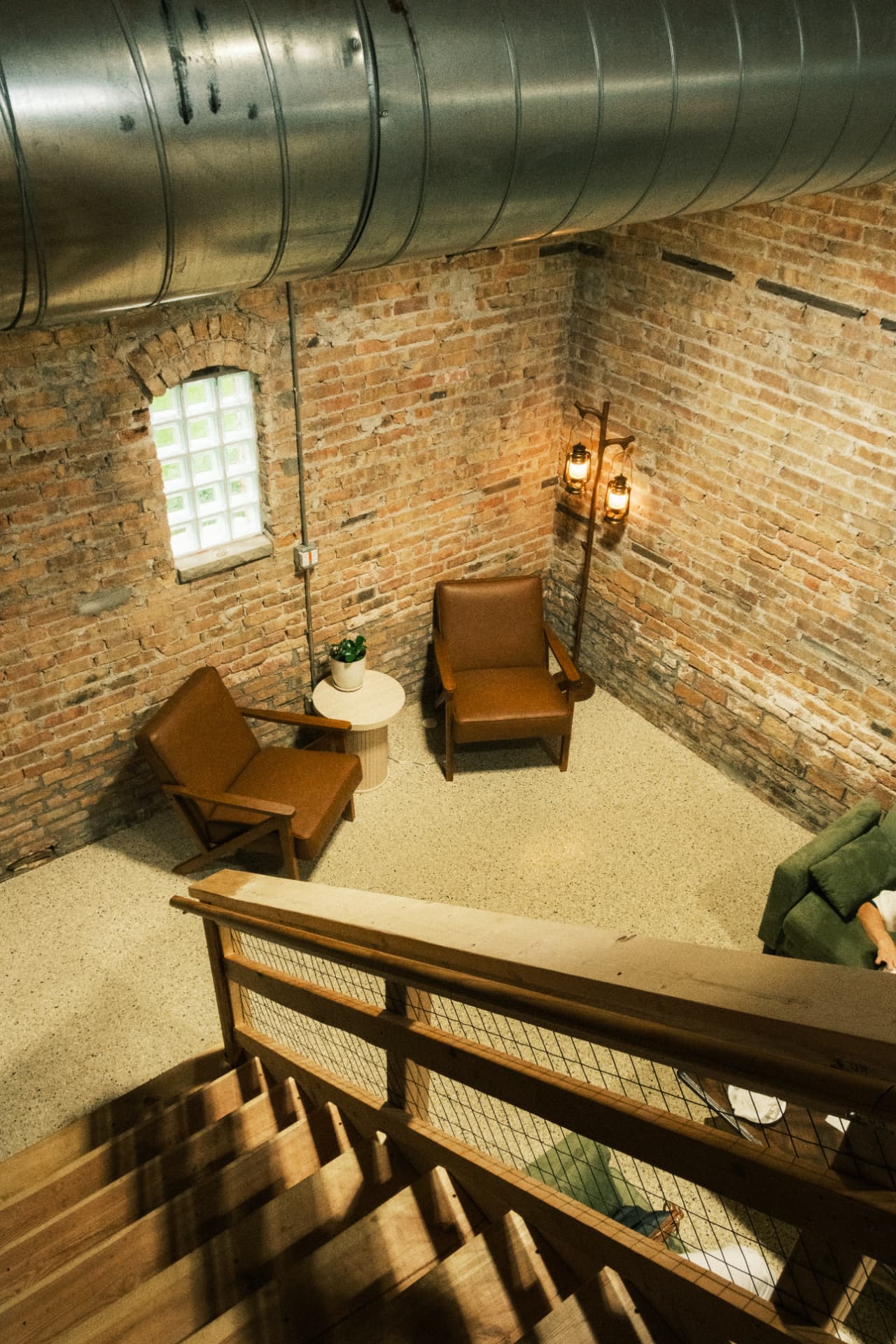 The lantern-lit lounge seating seen from the wooden stairs above