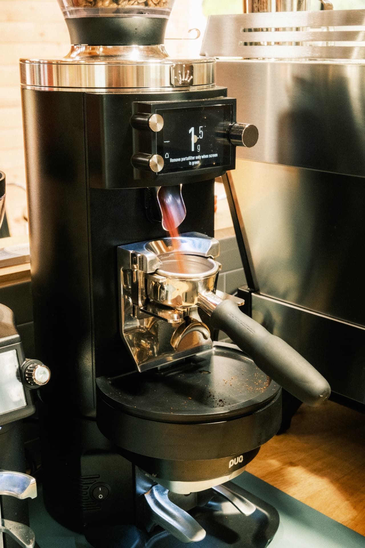 Fresh coffee grinding into a portafilter behind the DSCO counter